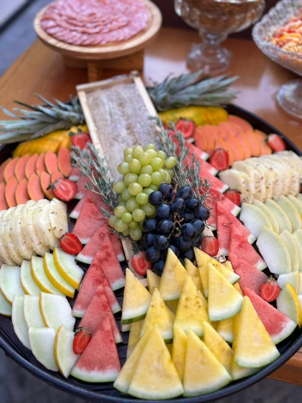 Mesa de frutas e frios com abacaxi ao centro