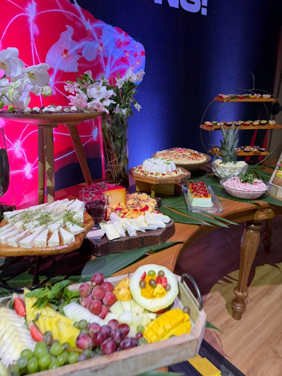 Mesa de buffet montada em evento com painel iluminado