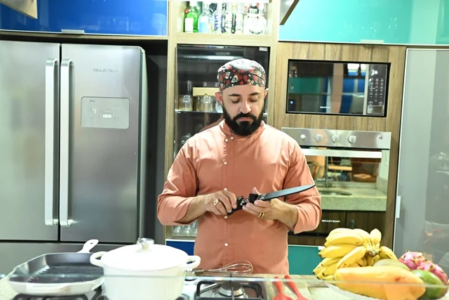Chef Pedro Ernesto afiando a faca na bancada da aula